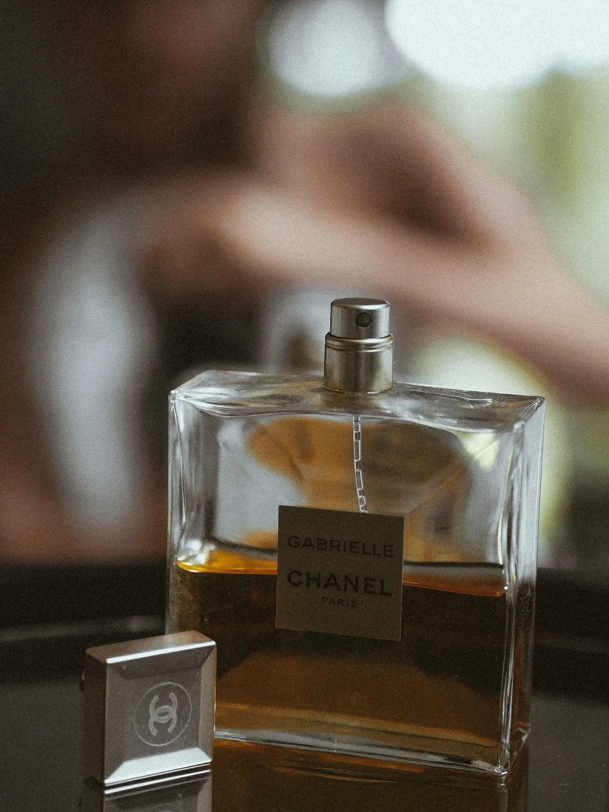 clear glass perfume bottle on brown wooden table