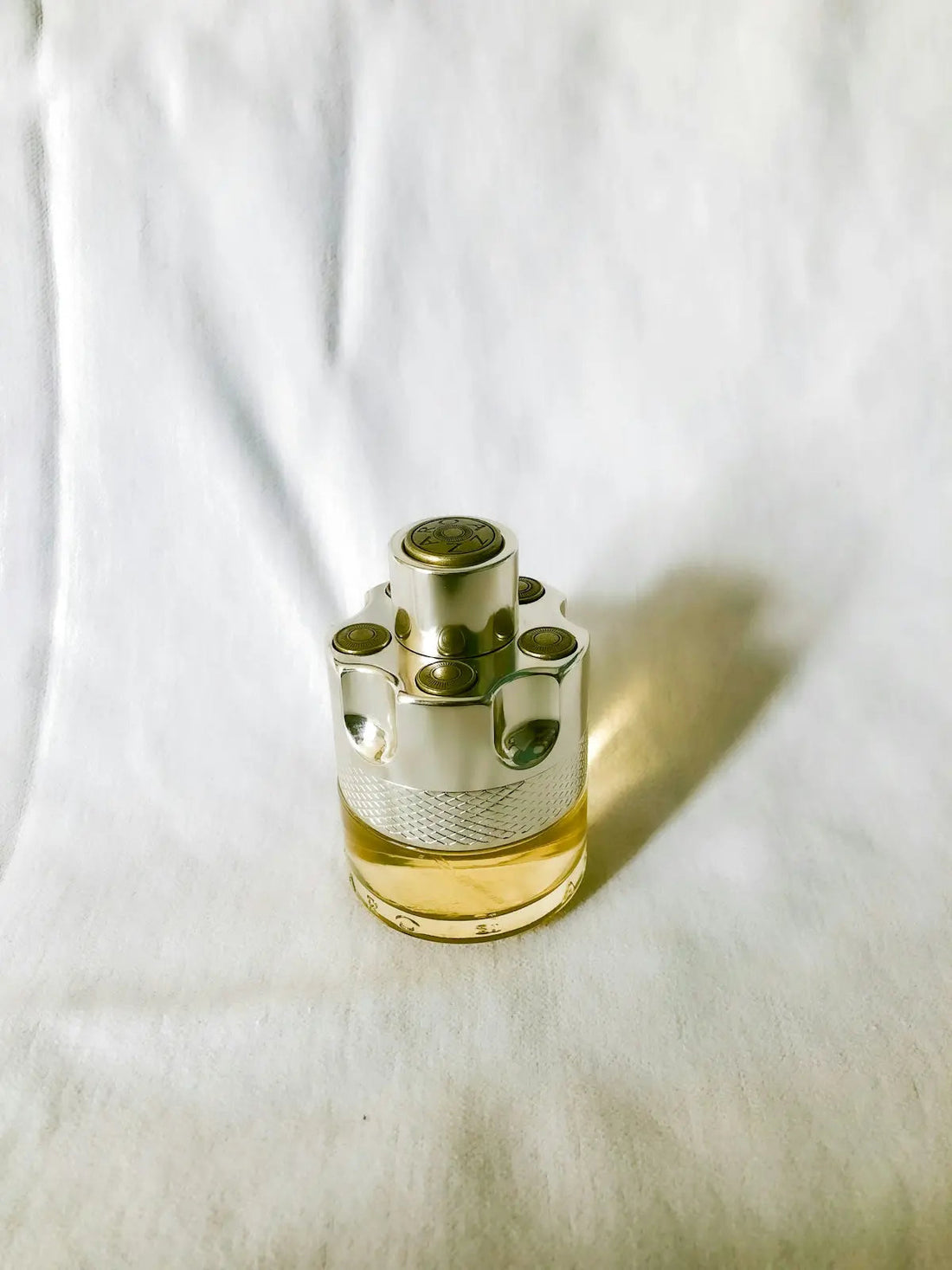 gold and silver steel container on white textile